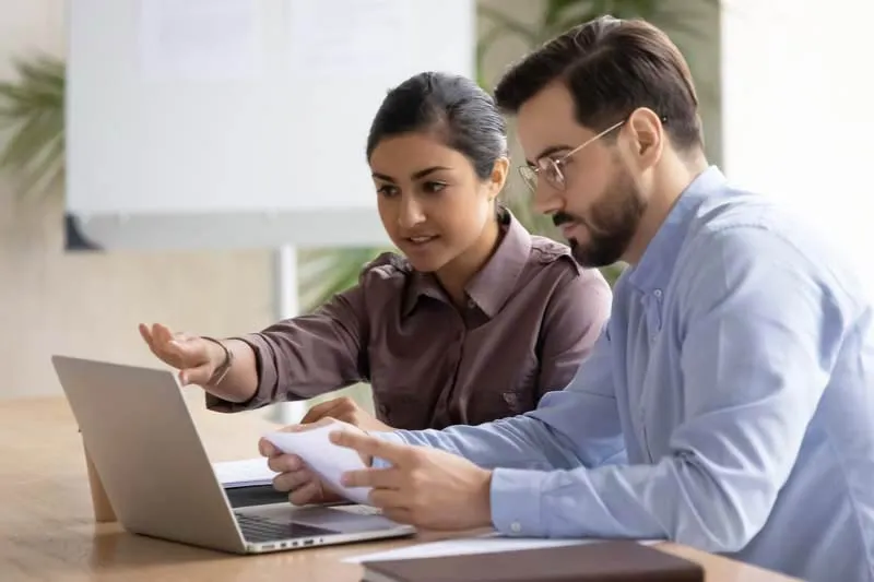 Two colleagues reviewing something on a laptop together