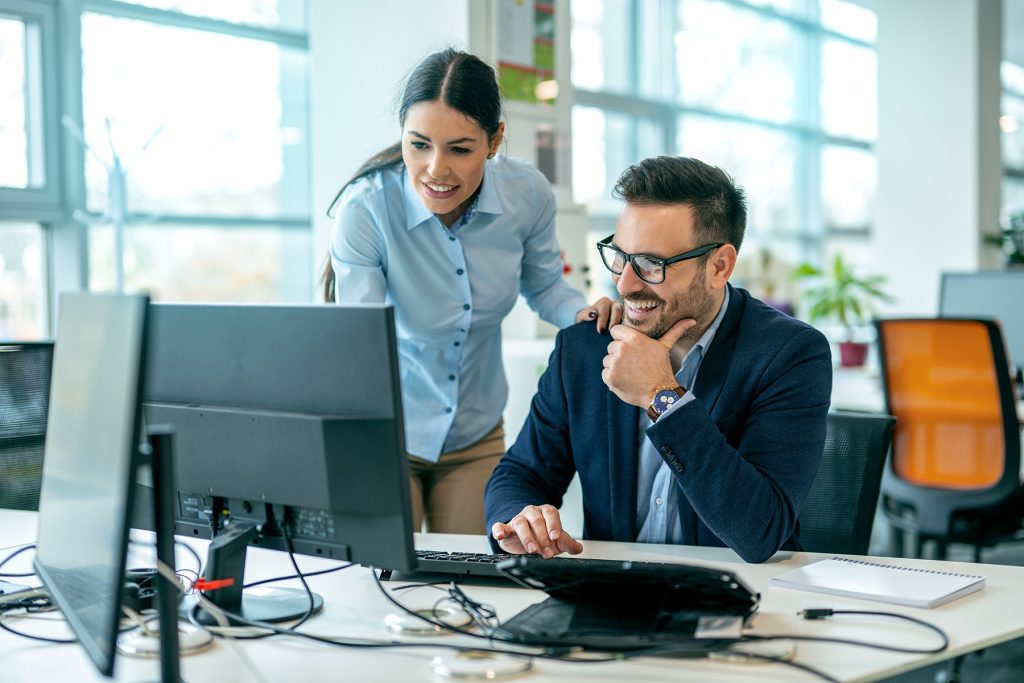Two people looking at a computer screen solving a problem
