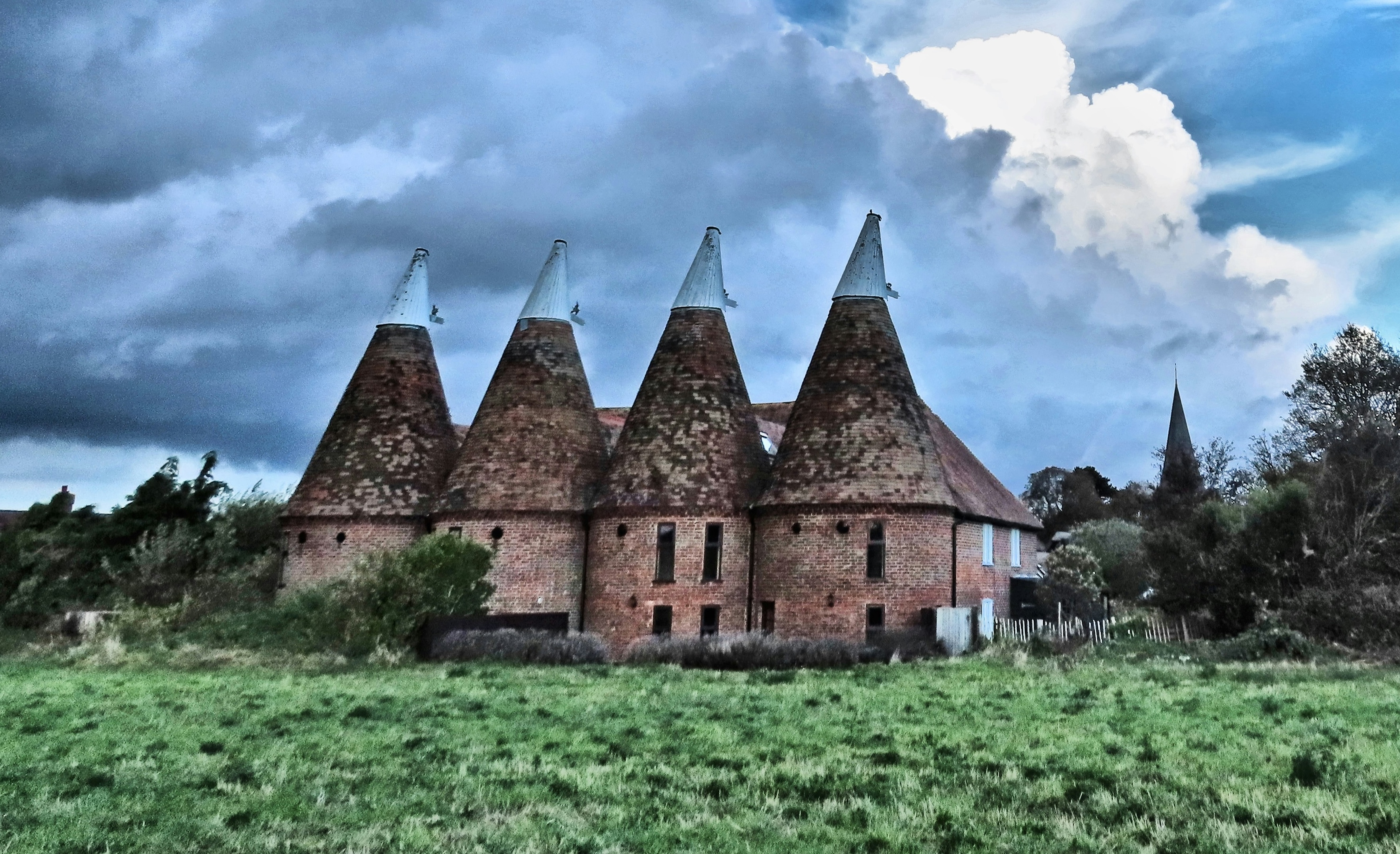 A very rural-looking oast building with its distinctive pointy roof